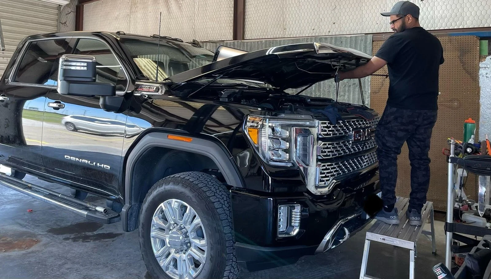 Paintless dent repair on a black GMC Denali at DFC Hail Dent Repair in Wylie, TX