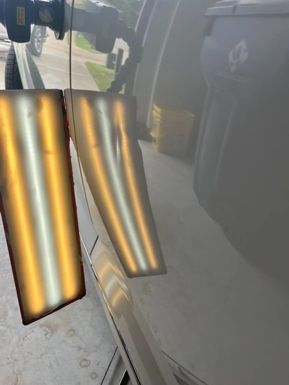 Door panel dent reflection under the paintless dent repair light